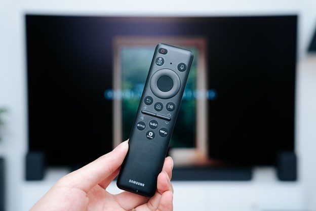 A hand holding a remote controlDescription automatically generated